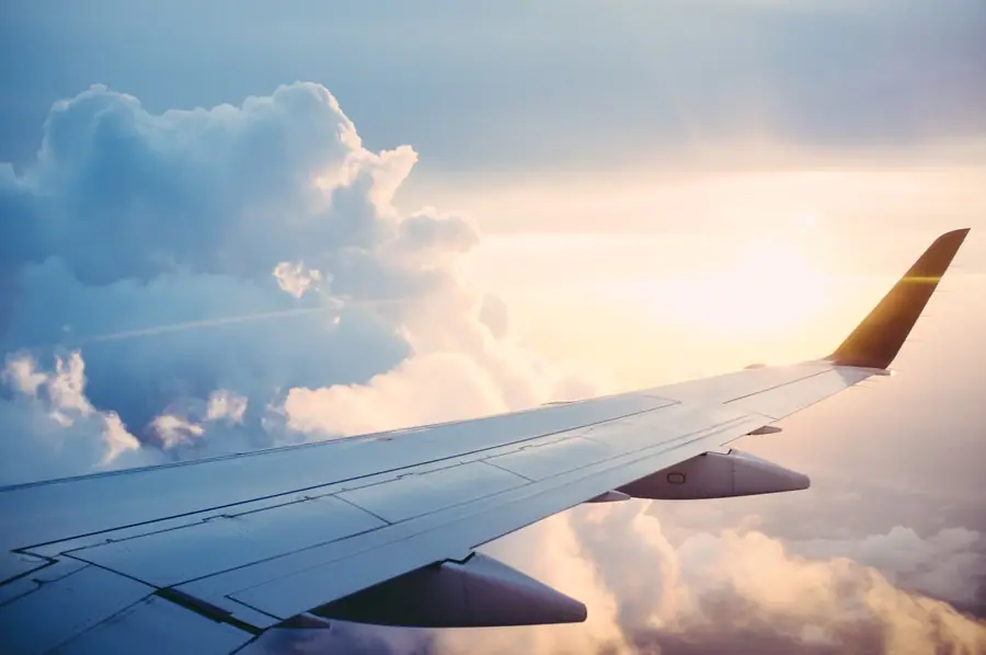 Airplane wing above the clouds — Bay Area airport transfer service